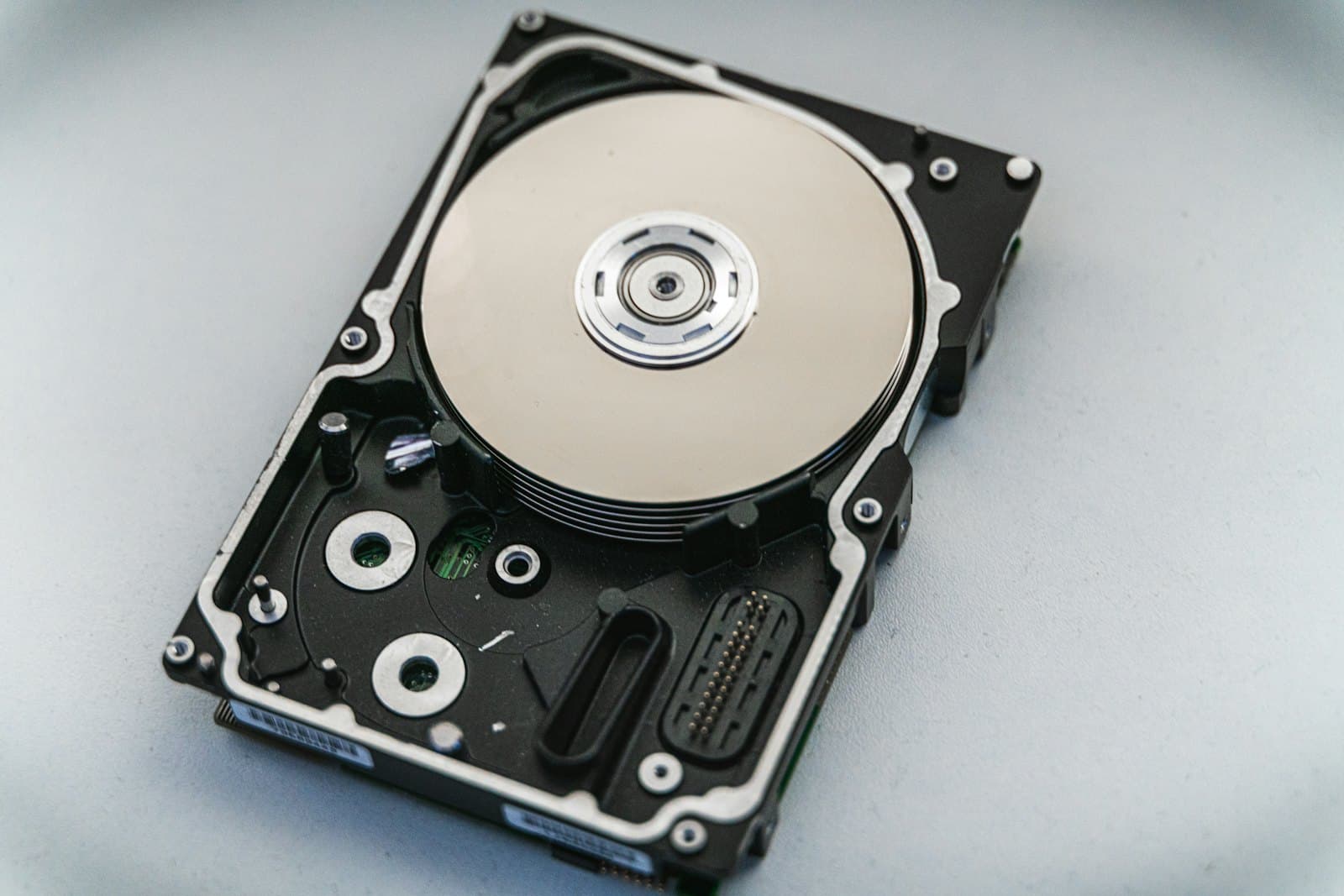 A hard disk drive with its cover removed, showing the platter and read arm.