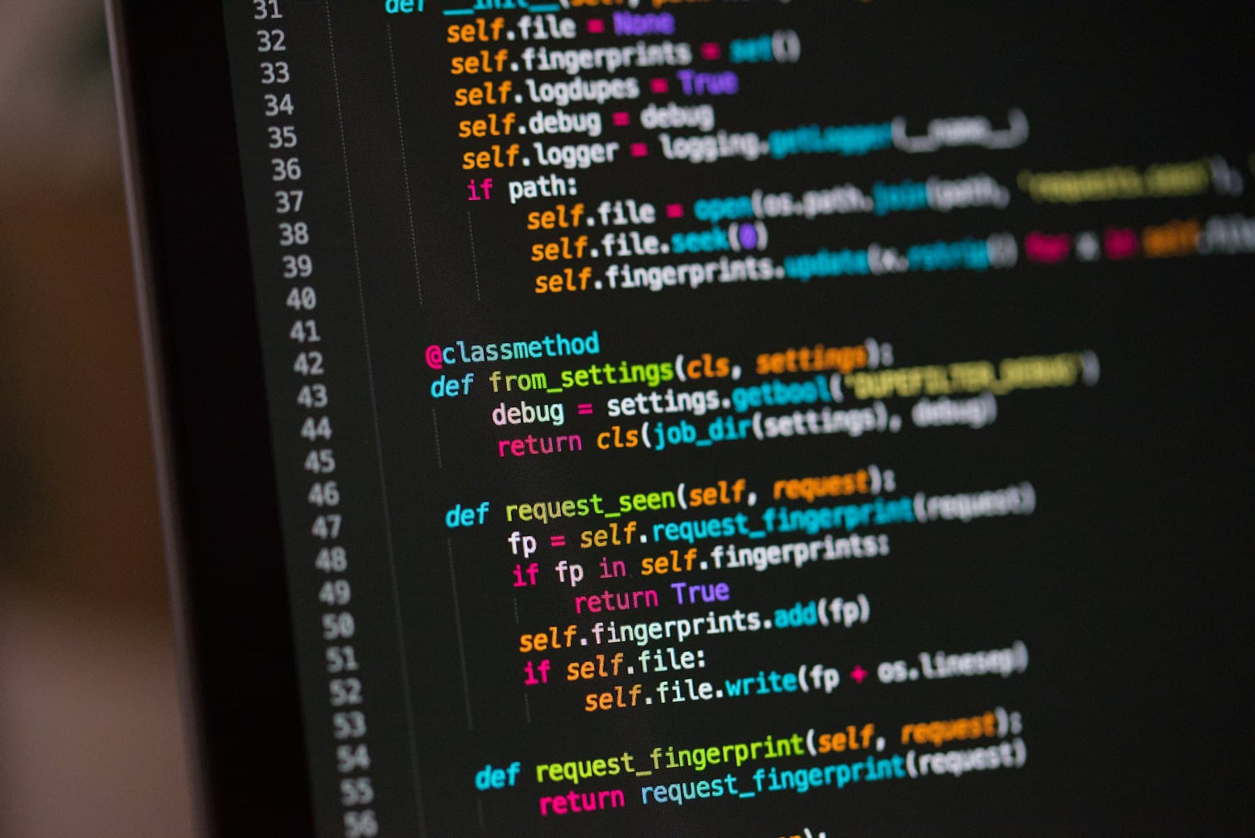 Syntax-highlighted code on a dark monitor, shot close and at an angle.